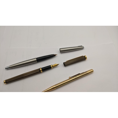 29 - Four pens to include a Parker biro, a gold coloured propelling pencil, a parker Fountain pen and gol... 