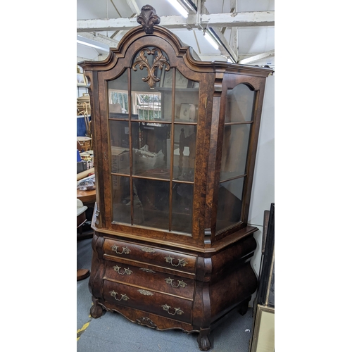 458 - A mid 20th century Dutch walnut veneered bombe display cabinet having a single door above three draw... 