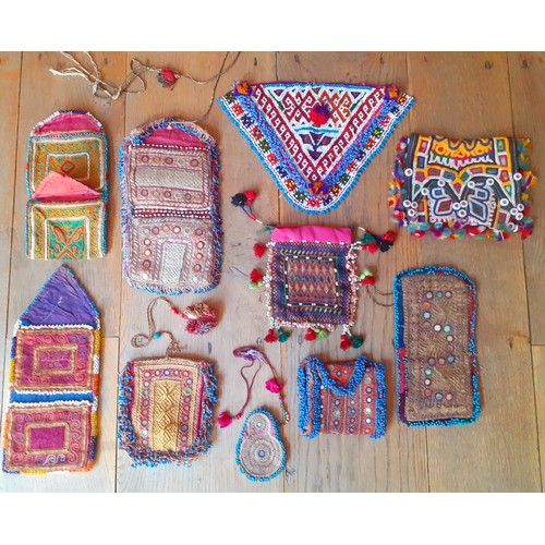 102 - A group of mid 20th Century and later Afghan and other hand embroidered purses and clothing segments... 