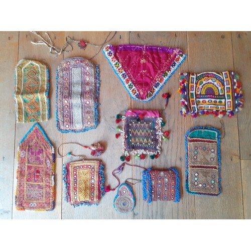 102 - A group of mid 20th Century and later Afghan and other hand embroidered purses and clothing segments... 