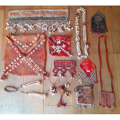 101 - A quantity of Banjara and other textiles to include purses and items decorated with cowrie beads and... 