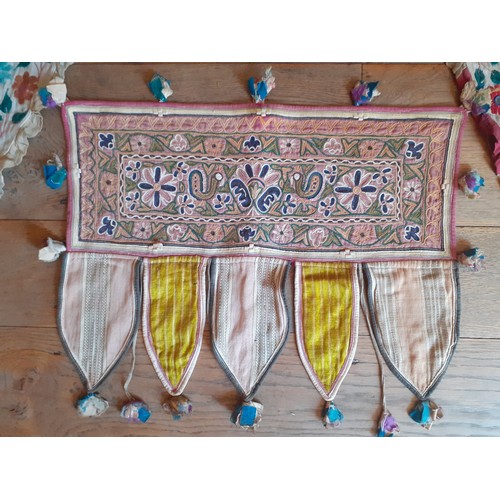 121 - Four vintage Indian hand-embroidered wall hangings and door Torans in various sizes and designs, the... 