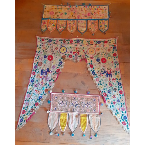 121 - Four vintage Indian hand-embroidered wall hangings and door Torans in various sizes and designs, the... 