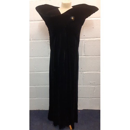 77 - A black velvet full length opera cape having a Gothic style raised collar with a hook and eye and si... 