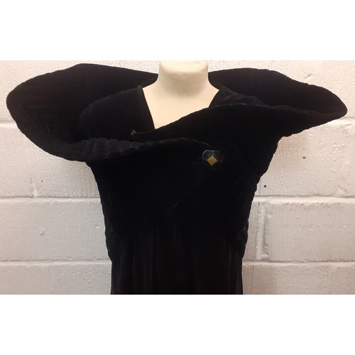 77 - A black velvet full length opera cape having a Gothic style raised collar with a hook and eye and si... 