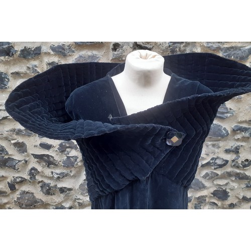 77 - A black velvet full length opera cape having a Gothic style raised collar with a hook and eye and si... 