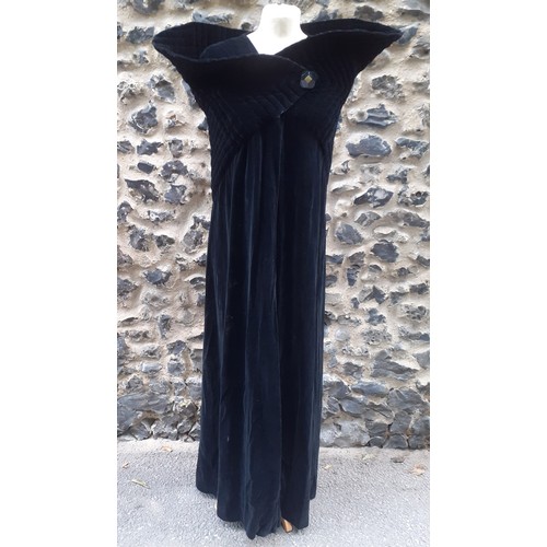 77 - A black velvet full length opera cape having a Gothic style raised collar with a hook and eye and si... 