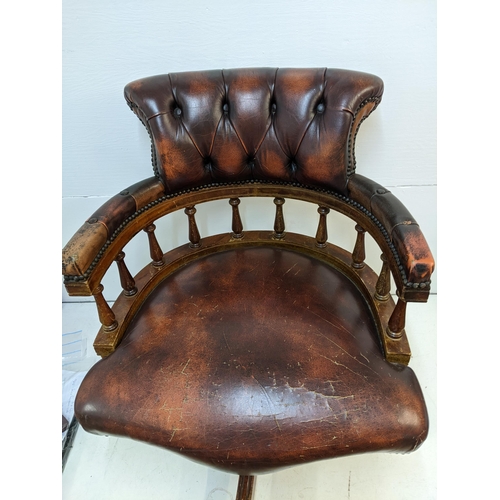 65 - A late 20th century brown leather upholstered and mahogany rotating, height adjustable desk chair

L... 