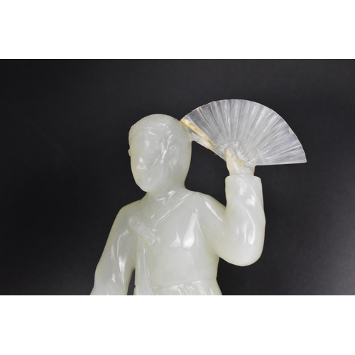 10 - A 20th Chinese jade coloured sculpture of a Geisha figure in a dress, holding a fan aloft in her lef... 