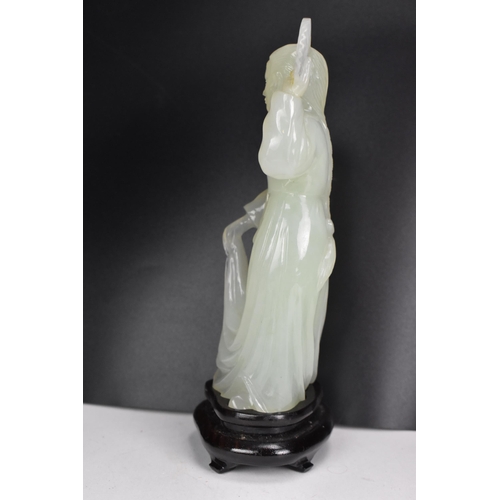 10 - A 20th Chinese jade coloured sculpture of a Geisha figure in a dress, holding a fan aloft in her lef... 