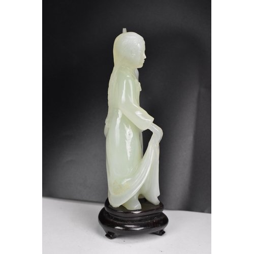 10 - A 20th Chinese jade coloured sculpture of a Geisha figure in a dress, holding a fan aloft in her lef... 