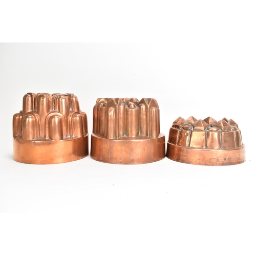 104 - Three 19th century copper jelly moulds, each of castellated form on stepped bases with impressed mar... 