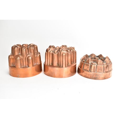 104 - Three 19th century copper jelly moulds, each of castellated form on stepped bases with impressed mar... 