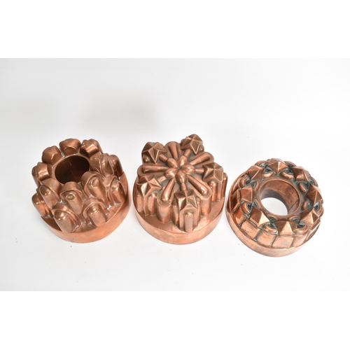 104 - Three 19th century copper jelly moulds, each of castellated form on stepped bases with impressed mar... 