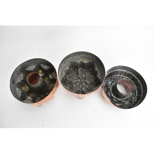 104 - Three 19th century copper jelly moulds, each of castellated form on stepped bases with impressed mar... 