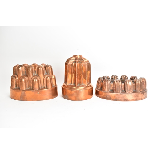 105 - Three 19th century copper jelly moulds, each of castellated form on stepped bases with impressed mar... 