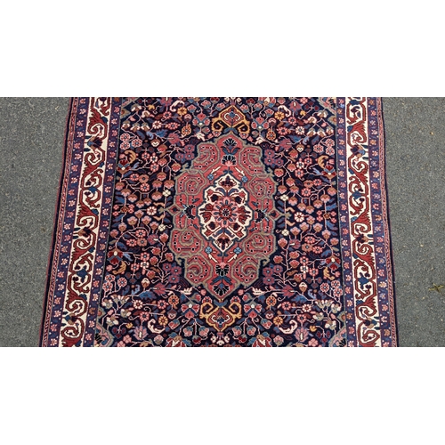 125 - A Persian Malayer hand woven rug, having a central flower head motif surrounded by flowerheads and f... 