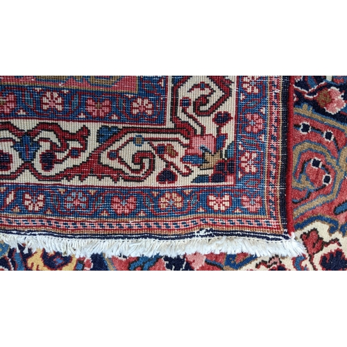 125 - A Persian Malayer hand woven rug, having a central flower head motif surrounded by flowerheads and f... 