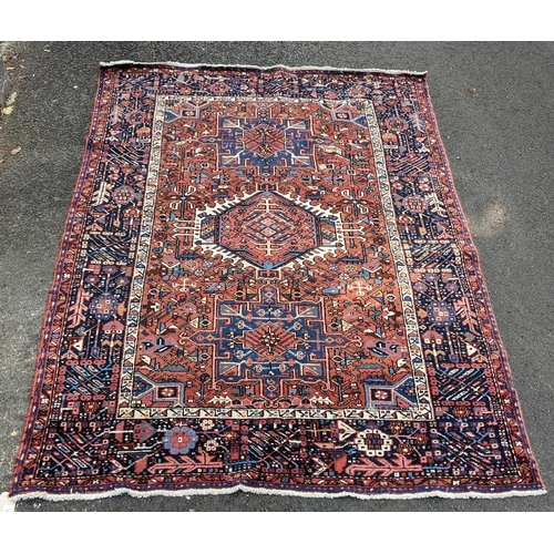 128 - A Persian Karadja hand woven rug, having three central medallions, red ground, triple guard border w... 