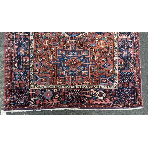 128 - A Persian Karadja hand woven rug, having three central medallions, red ground, triple guard border w... 