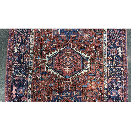 128 - A Persian Karadja hand woven rug, having three central medallions, red ground, triple guard border w... 