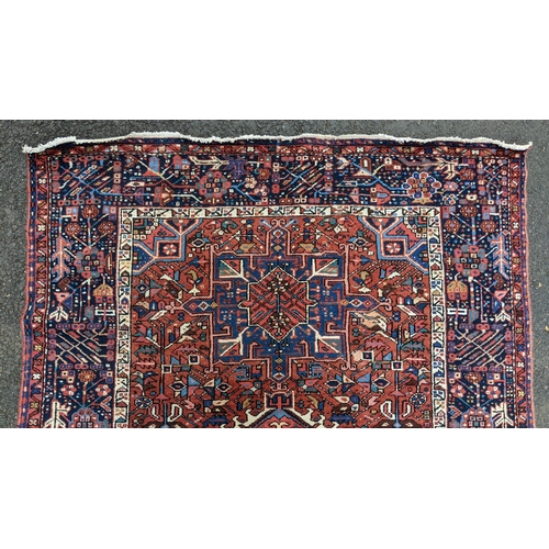 128 - A Persian Karadja hand woven rug, having three central medallions, red ground, triple guard border w... 