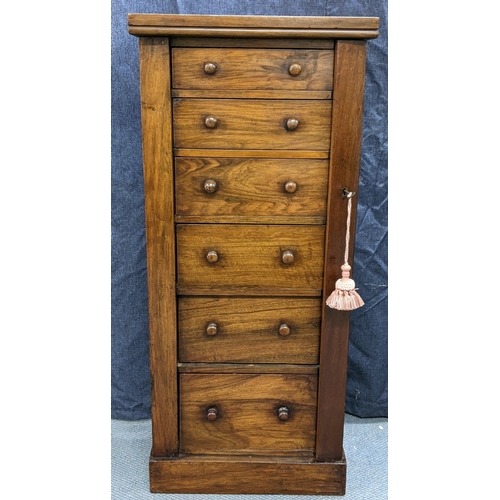 133 - A Victorian walnut wellington chest, having six graduated drawers with bun shaped handles, two side ... 