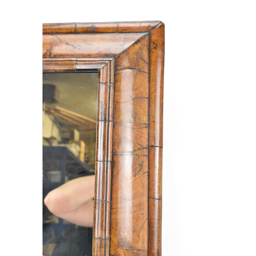 136 - A William and Mary walnut veneered mirror, circa 1690, the later plain mirror plate within a cushion... 