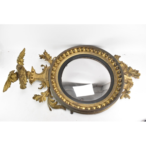 141 - A Regency wall mirror, having a convex plate in a gilt moulded and carved giltwood frame with a ball... 