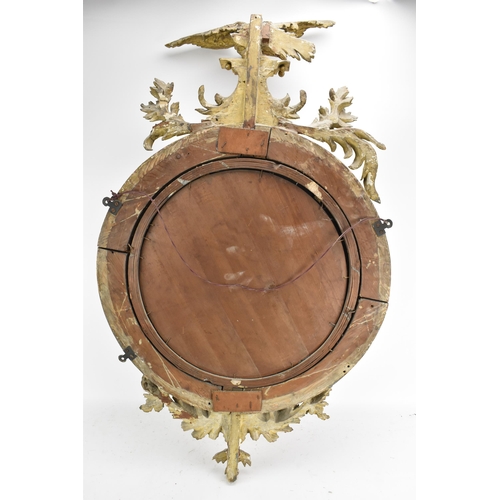 141 - A Regency wall mirror, having a convex plate in a gilt moulded and carved giltwood frame with a ball... 