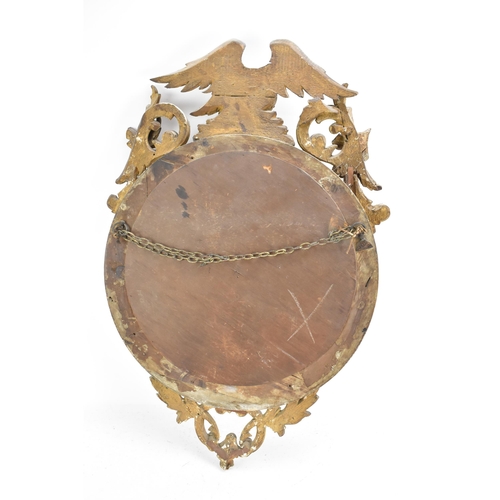 142 - A Regency wall mirror, having a convex plate in a gilt moulded and carved giltwood frame with a ball... 