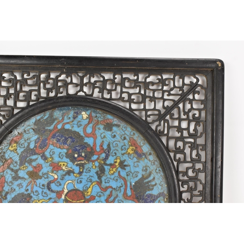 18 - A 19th Chinese cloisonne panel and mirror, housed in an ebonised pierced frame with, the panel havin... 