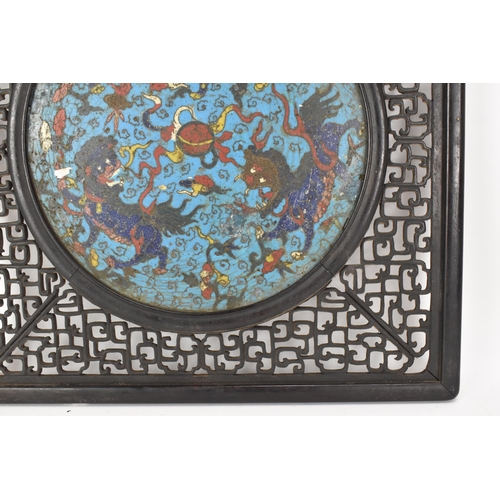 18 - A 19th Chinese cloisonne panel and mirror, housed in an ebonised pierced frame with, the panel havin... 