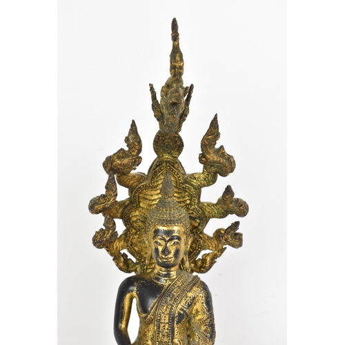 48 - A 19th century Thai gilt bronze Buddha, Cast seated in meditation on a coiled snake, his hands held ... 