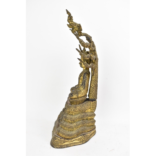 48 - A 19th century Thai gilt bronze Buddha, Cast seated in meditation on a coiled snake, his hands held ... 