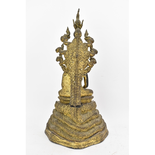 48 - A 19th century Thai gilt bronze Buddha, Cast seated in meditation on a coiled snake, his hands held ... 