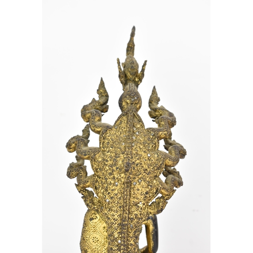 48 - A 19th century Thai gilt bronze Buddha, Cast seated in meditation on a coiled snake, his hands held ... 