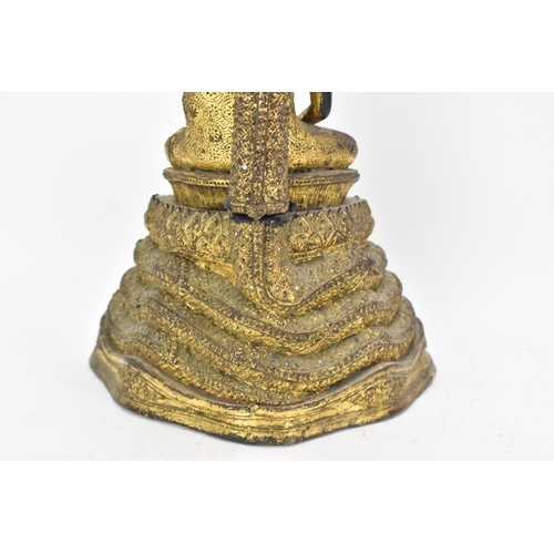 48 - A 19th century Thai gilt bronze Buddha, Cast seated in meditation on a coiled snake, his hands held ... 