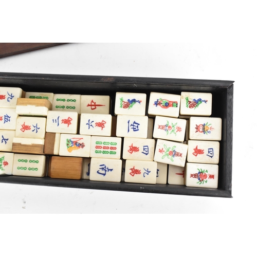 61 - An early 20th century Chinese Mah Jong set, contained in an ebonised case with an inlaid lid with bo... 