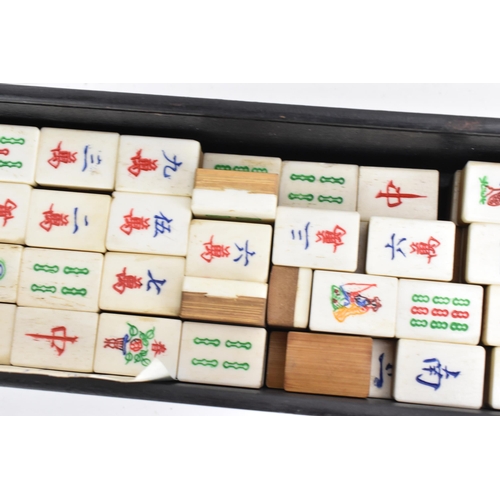 61 - An early 20th century Chinese Mah Jong set, contained in an ebonised case with an inlaid lid with bo... 