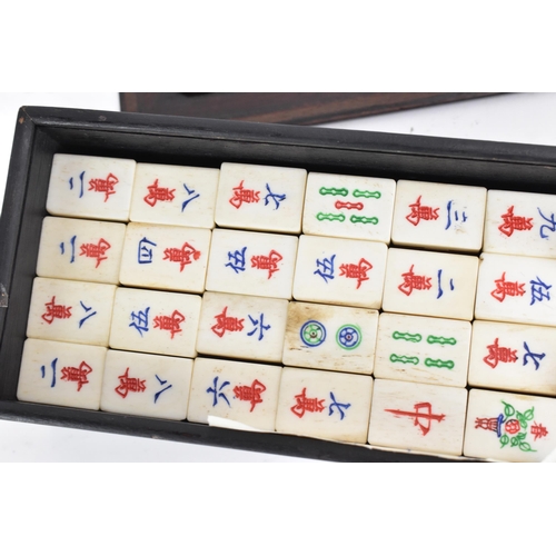 61 - An early 20th century Chinese Mah Jong set, contained in an ebonised case with an inlaid lid with bo... 