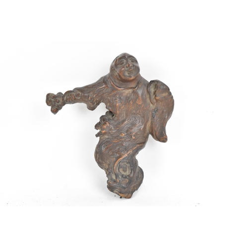 65 - A Chinese Qing dynasty rootwood carving depicting a a figure holding an object to his right hand, 14... 