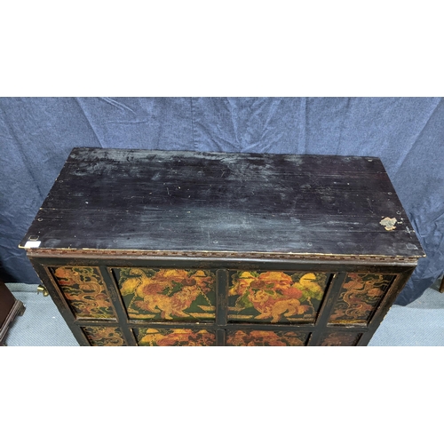 76 - A 19th century Tibetan cabinet, lacquered and polychrome painted with panels depicting foo dogs and ... 