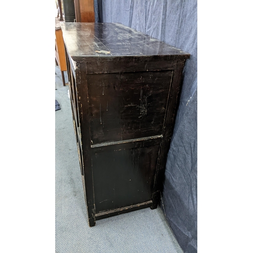 76 - A 19th century Tibetan cabinet, lacquered and polychrome painted with panels depicting foo dogs and ... 