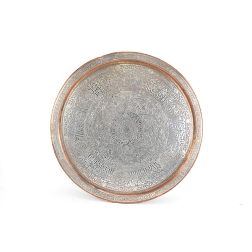 82 - An Iranian Qajar large circular copper tray, circa 1900, with white metal overlaid, decorated with o... 