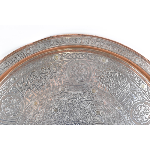 82 - An Iranian Qajar large circular copper tray, circa 1900, with white metal overlaid, decorated with o... 