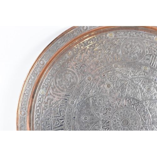 82 - An Iranian Qajar large circular copper tray, circa 1900, with white metal overlaid, decorated with o... 