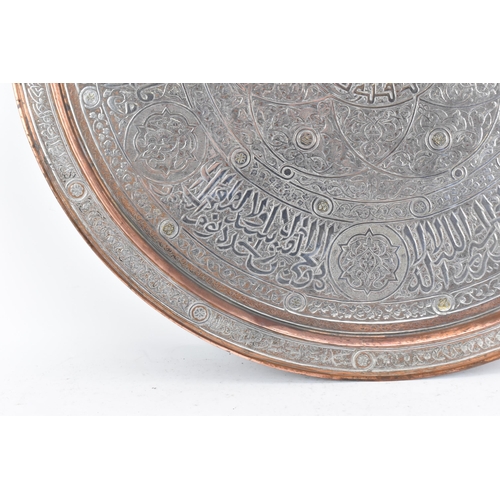 82 - An Iranian Qajar large circular copper tray, circa 1900, with white metal overlaid, decorated with o... 