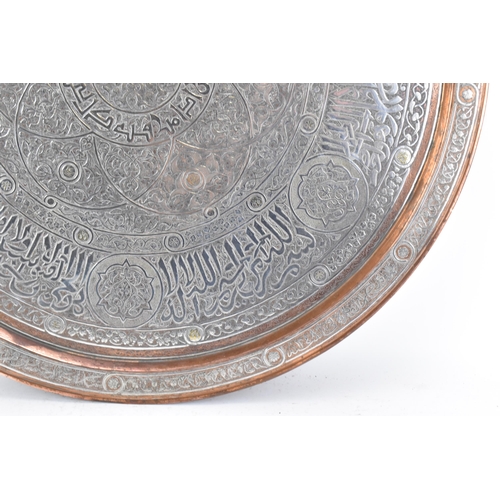 82 - An Iranian Qajar large circular copper tray, circa 1900, with white metal overlaid, decorated with o... 