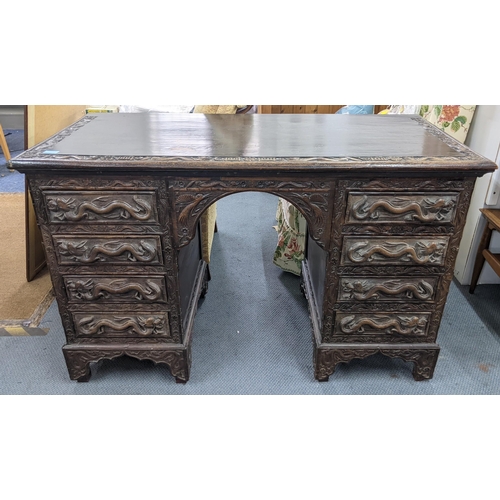 83 - An early 20th century Chinese export padouk wood twin pedestal desk, relief carved decorated with dr... 